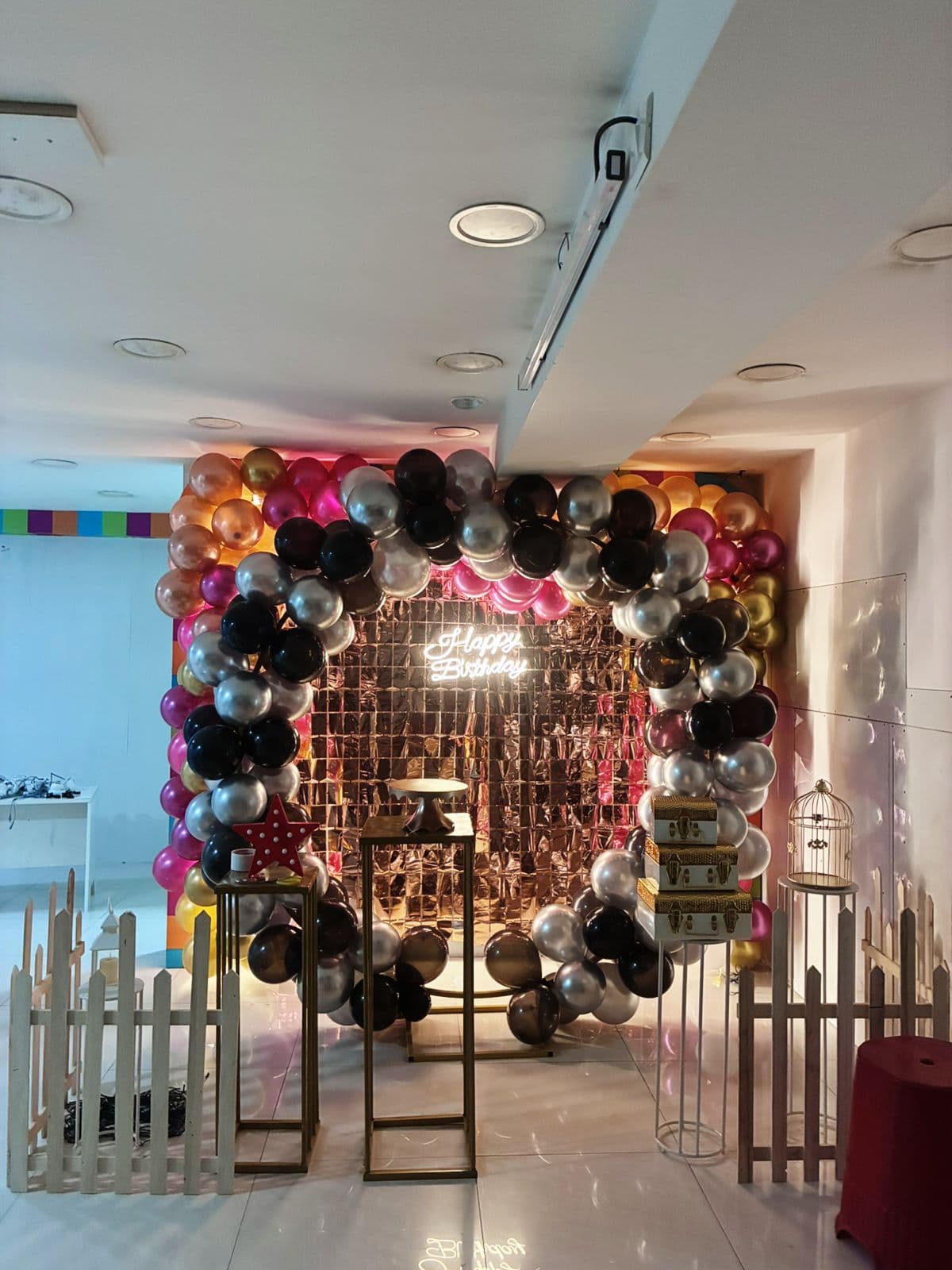 Happy Birthday neon on rose gold sequin wall with balloon ring