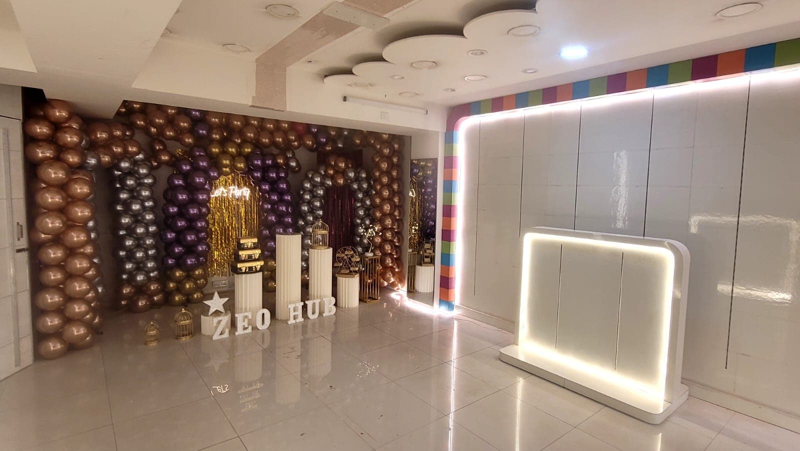 Zeo Hub decorated stage with purple and gold balloon arches